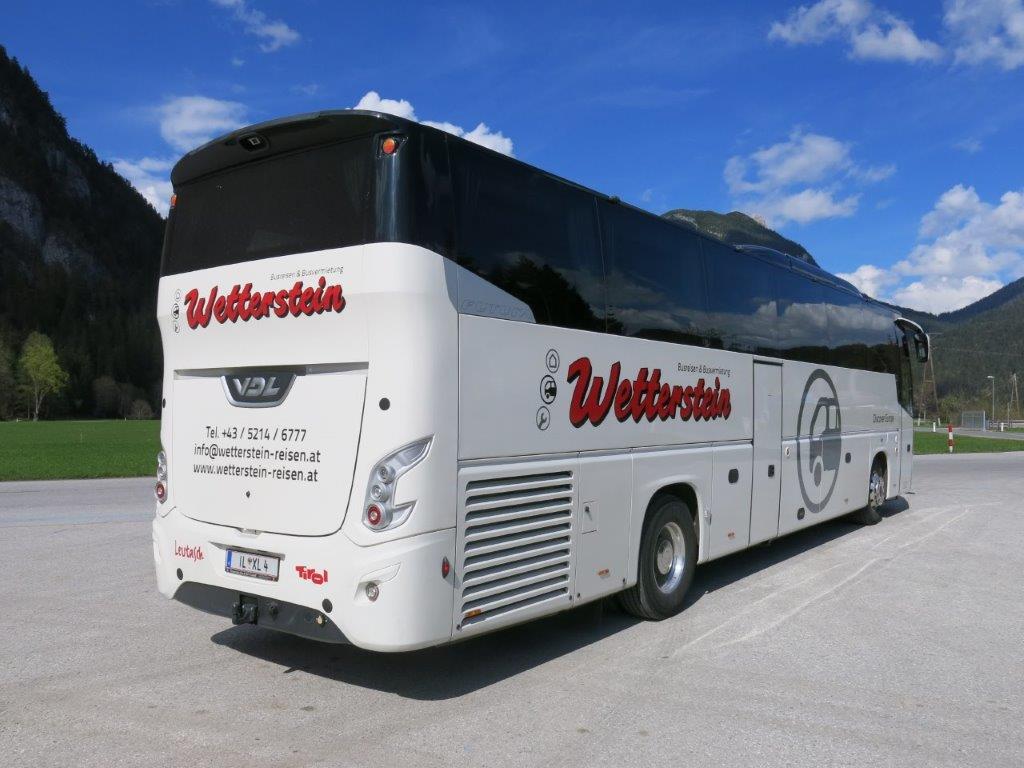 Reisebus von Wetterstein-Reisen vor sommerlicher Bergkulisse